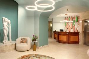 Un vestíbulo con una sala de espera con una silla y una mesa. en Zeus Essence Bucharest Venezia, en Bucarest