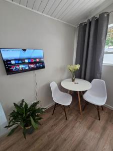 Habitación con mesa, 2 sillas y TV. en SleepINN at Dumont, en Paarl