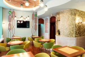Un comedor con mesas y sillas verdes. en Zeus Essence Bucharest Venezia, en Bucarest