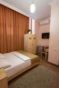a bedroom with a large bed and a table at Americana By California in Yerevan