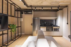a living room with a couch and a kitchen at Moinho Moradia in Juiz de Fora