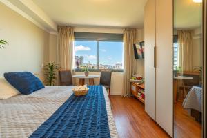 a bedroom with a bed and a view of a city at Skyline Moinhos de Vento in Porto Alegre +62 photos