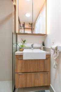 a bathroom with a sink and a mirror at Skyline Moinhos de Vento in Porto Alegre