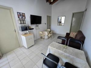 a living room with a table and chairs and a tv at Esquina Mburucuya in Asunción
