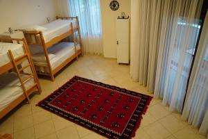 Cette chambre comprend 2 lits superposés et un tapis rouge. dans l'établissement Balkan Hostel, à Tirana