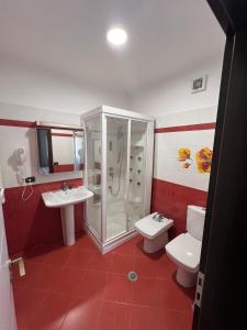 a bathroom with a shower and a toilet and a sink at Manga Luxury Apartments - 2 Bedrooms in Gjirokastër