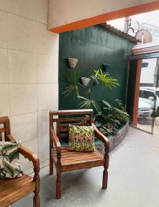 a bench with a pillow on it next to a plant at Casa Laranja Hostel in Niterói