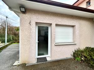 Gîte avec Terrasse et parking privé في Charnècles: بيت ابيض بباب ونافذة