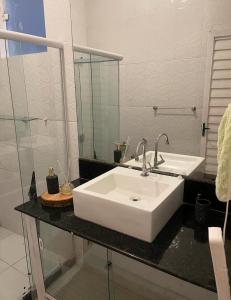 a bathroom with a white sink and a mirror at Casa Laranja Hostel in Niterói