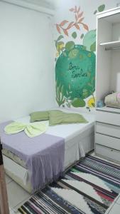 a bedroom with a bed with a mural on the wall at Casa Laranja Hostel in Niterói