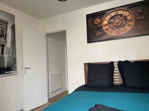 a bedroom with a bed with a clock on the wall at T2 COCOON Centre ville in Marmande