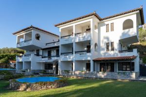 an exterior view of a white building with a swimming pool at Villa Spartias in Skiathos