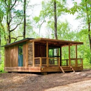 a wooden cabin in the middle of a forest at La Clairière - Écocamping en vallée de la Dordogne in Lamothe-Fénelon