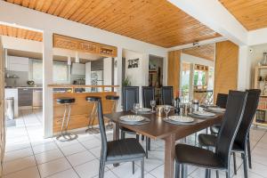 ドゥサールにあるMaison Lacustre - Maison contemporaine avec vue panoramique sur le lac d'Annecyのダイニングルーム(テーブル、黒い椅子付)