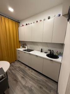 a kitchen with white cabinets and a sink at Apartament for Guest in Jelgava