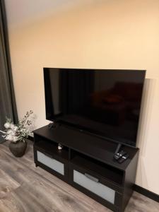 a flat screen tv on a black stand in a living room at Apartament for Guest in Jelgava +14 photos