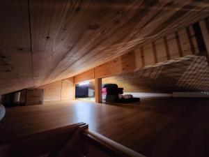 Chalet en montagne في Sembrancher: غرفة فارغة مع أرضية خشبية وسقف خشبي