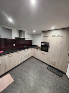 Chalet en montagne في Sembrancher: مطبخ كبير مع خزائن وأجهزة خشبية +4 صور