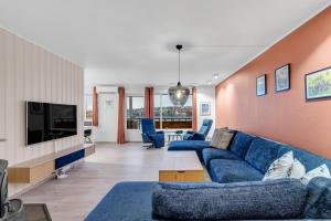 a living room with a blue couch and a tv at Apartment with view of the city in Hjorten