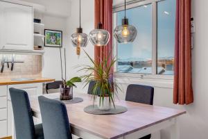 a dining room with a table and chairs and a window at Apartment with view of the city in Hjorten
