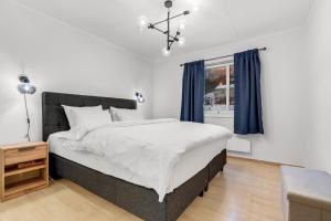 a bedroom with a large bed with blue curtains at Apartment with view of the city in Hjorten