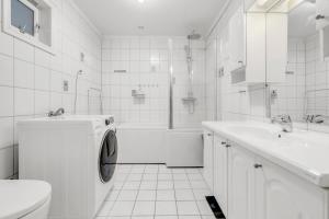 a white bathroom with a washing machine in it at Apartment with view of the city in Hjorten +15 photos