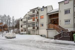 an apartment building with a van parked in the snow at Apartment with view of the city in Hjorten