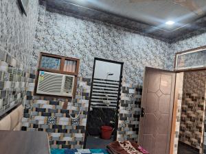 een kamer met een muur bedekt met tegels bij Nidhi dham inn in Vrindāvan +4 foto's