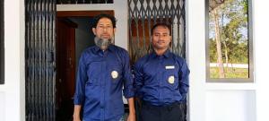 Noor Aman Guest House的两名身穿蓝色衬衫的男子站在门前