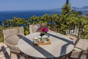 a table with a vase of flowers on it at Olive Resort in Petrovac na Moru