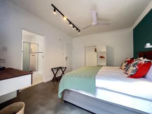 a bedroom with a large white bed with red pillows at The Lookout Guesthouse in Uvongo Beach +25 photos