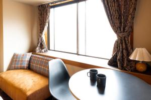 a room with a table and a couch and a window at Meijo Lemon Stay in Nagoya +13 photos