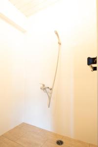 a shower in a room with a white wall at Meijo Lemon Stay in Nagoya