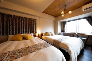 a hotel room with two beds and a window at Meijo Lemon Stay in Nagoya