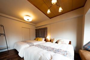 two beds sitting next to each other in a room at Meijo Lemon Stay in Nagoya