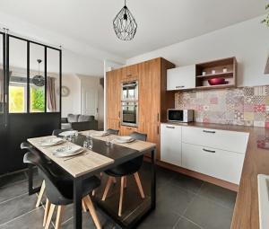 une cuisine et une salle à manger avec une table et des chaises dans l'établissement Maison lumineuse avec terrasse en plein centre, à Angoulême