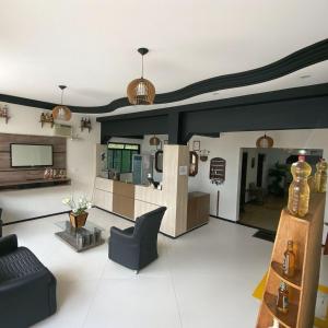 a living room with a couch and a tv at Hotel Minas Brasil in Salinas