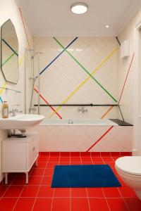 Un baño con suelo rojo, lavabo e inodoro. en Flora's Palace - The Hague Scheveningen, en La Haya 39 fotos más