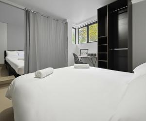 une chambre avec un grand lit blanc et un bureau dans l'établissement Maison lumineuse avec terrasse en plein centre, à Angoulême