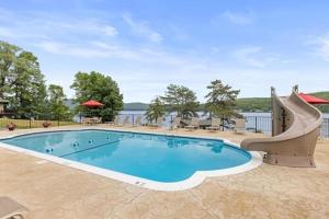 a swimming pool with a slide next to the water at Sun Castle Resort in Lake George