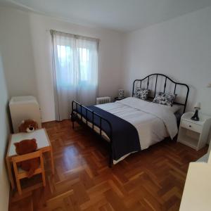 una camera da letto con un letto e un pavimento in legno di Apartman Ema a Tar