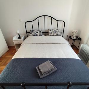 una camera da letto con un grande letto con struttura nera di Apartman Ema a Tar