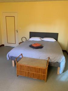 a bedroom with a large bed with a ottoman on it at L'Arbre de Vie in Montmarault