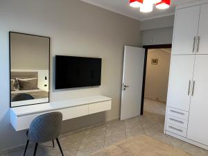 a living room with a television and a bedroom at Manga Luxury Apartments - 2 Bedrooms in Gjirokastër