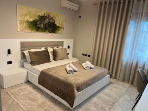 a bedroom with a bed with two towels on it at Manga Luxury Apartments - 2 Bedrooms in Gjirokastër