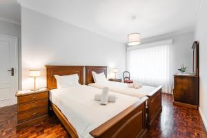 a bedroom with two beds with white sheets at GuestReady - Urban rustic in Esposende in Esposende