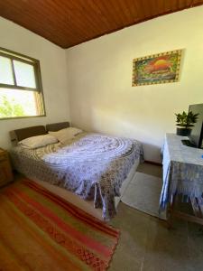 ein Schlafzimmer mit einem Bett in einem Zimmer mit Fenster in der Unterkunft Casa Canoa in Imbituba