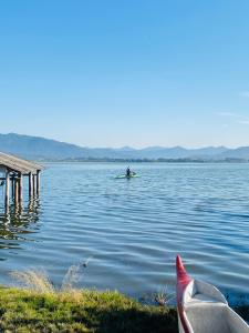 ein Mann in einem Kajak im Wasser in der Nähe eines Docks in der Unterkunft Casa Canoa in Imbituba