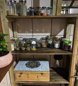 ein Regal mit Lebensmittelgläsern drauf in der Unterkunft Casa Canoa in Imbituba