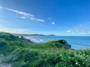 a view of the ocean from a hill with grass at Casa Canoa in Imbituba